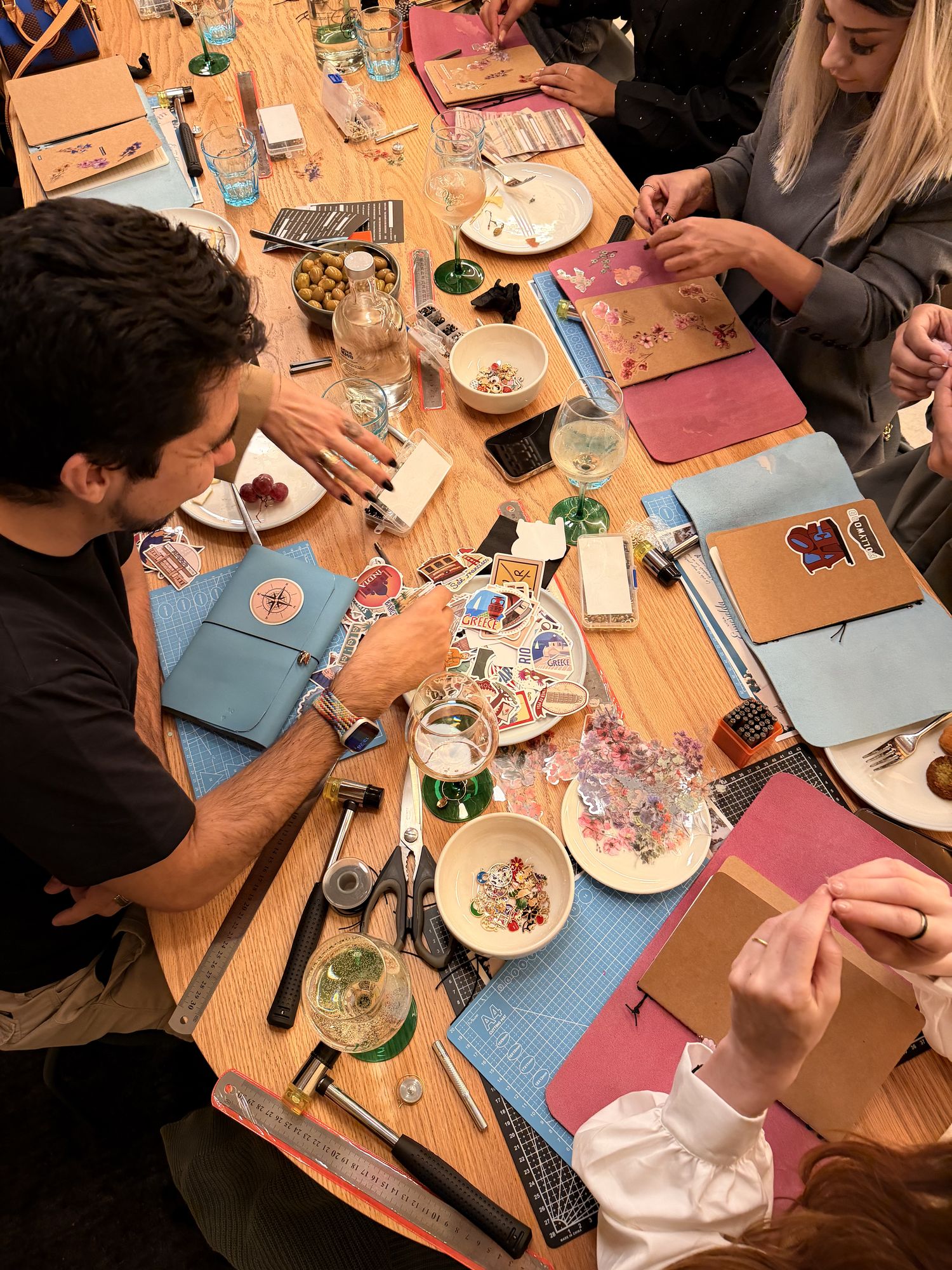 Mesa de Social Journals llena de gente creando sus cuadernos de piel